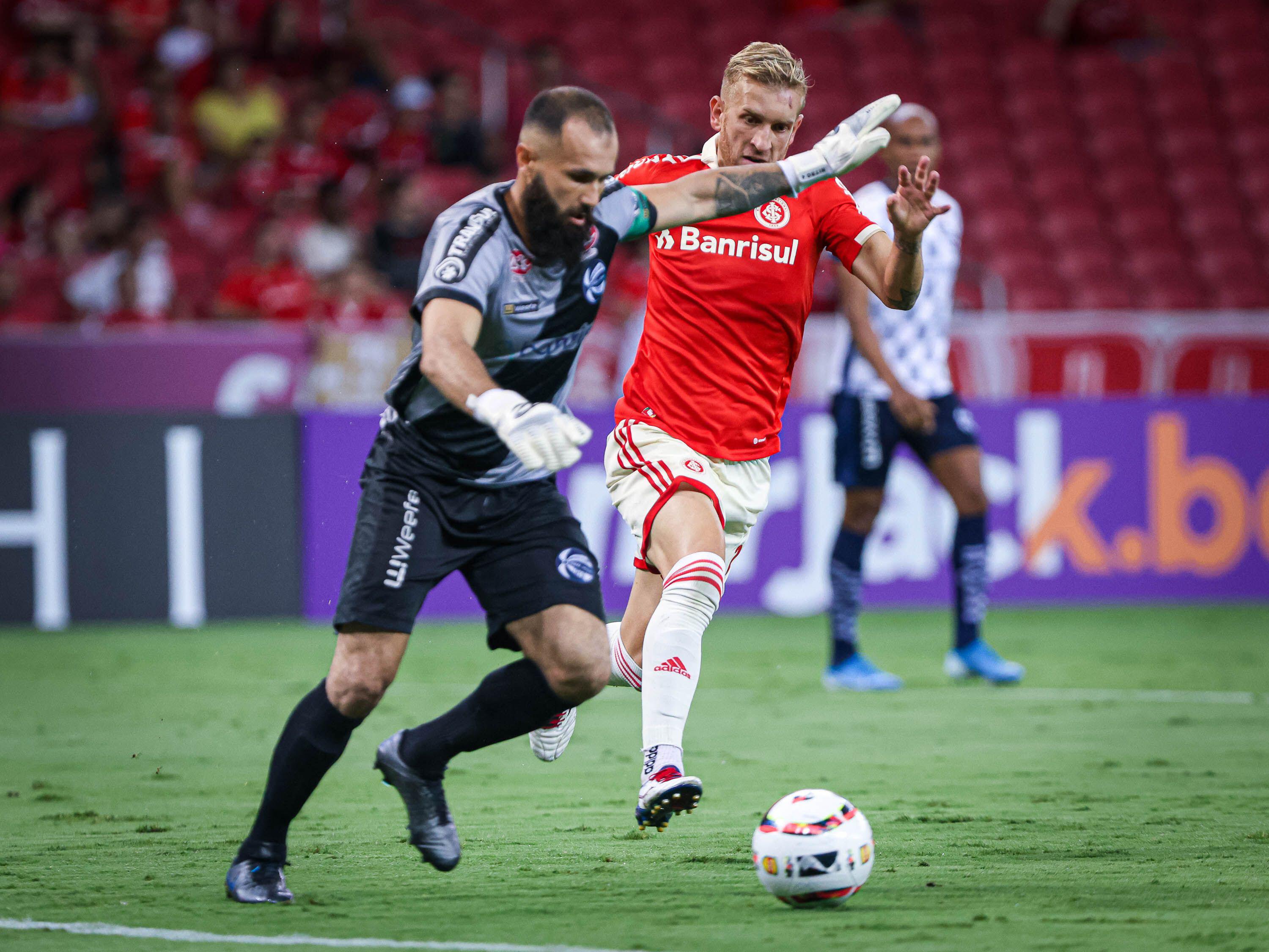 Sao Jose goalkeeper Fabio Rampi clears the ball under pressure from Internacional's Pedro Henrique in February 2023.