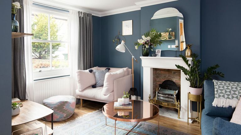 living room with blue wall sofa with cushion fireplace and white window