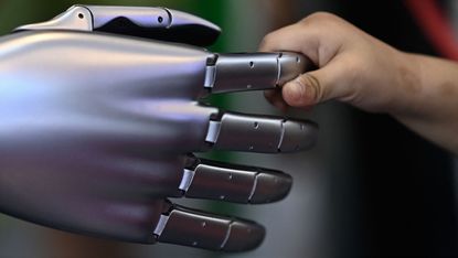 Robot hand held by human hand