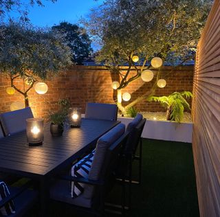 Sera's garden after the transformation, with a dining set and outdoor lights. Sera Sekerci's dad helped her transform her garden when trapped in the UK during lockdown