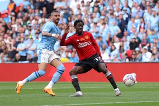 Kobbie Mainoo of Manchester United scores his team's second goal whilst under pressure from Kyle Walker of Manchester City during the Emirates FA Cup Final match between Manchester City and Manchester United at Wembley Stadium on May 25, 2024 in London, England. (Photo by Alex Pantling/Getty Images )