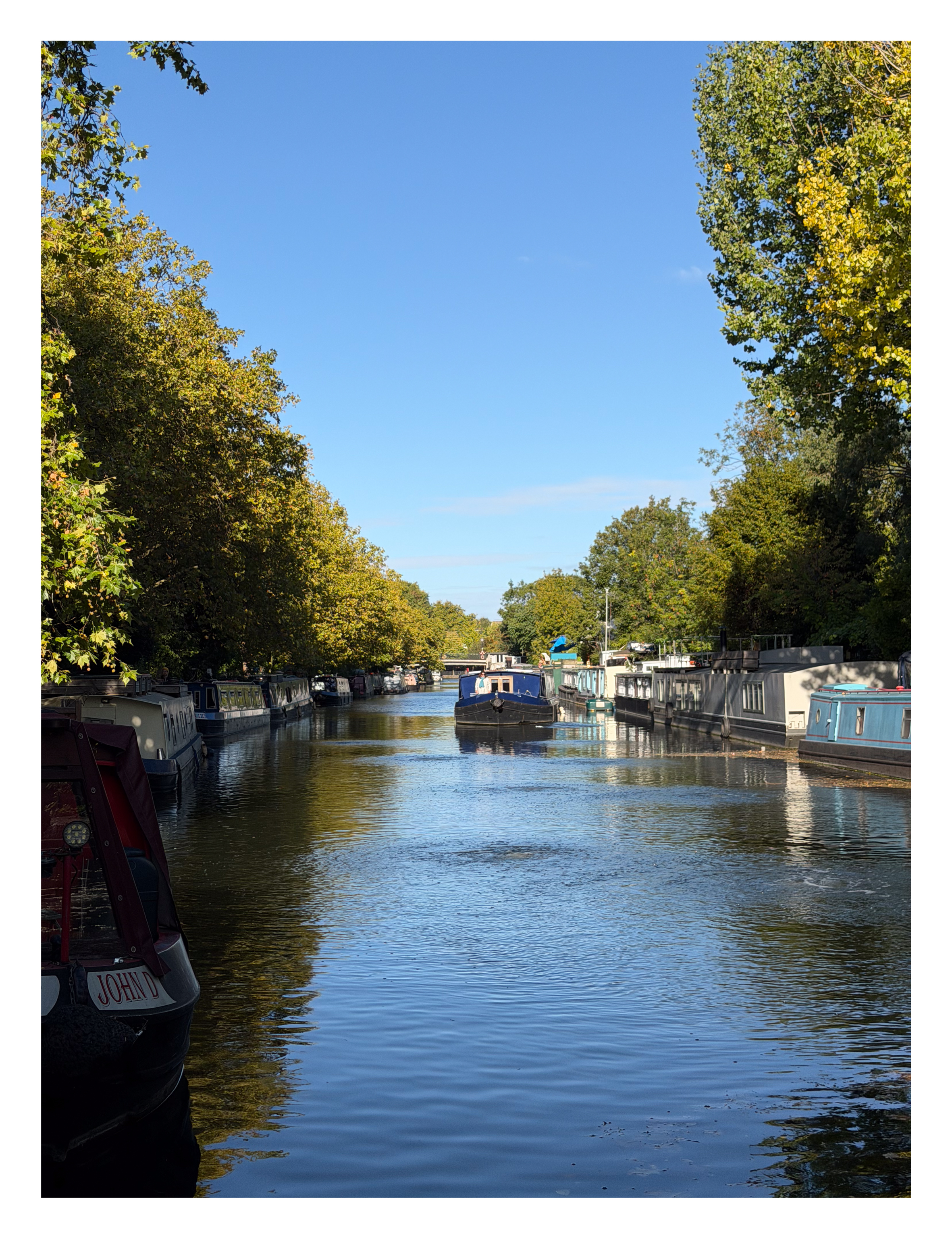 A canal boat sailing down a canal in London