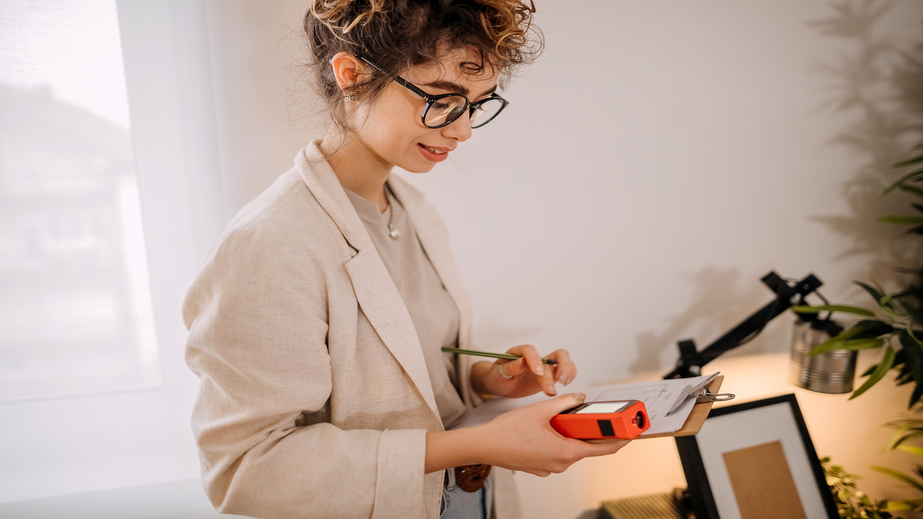 Female surveyor checking tool during house surveys