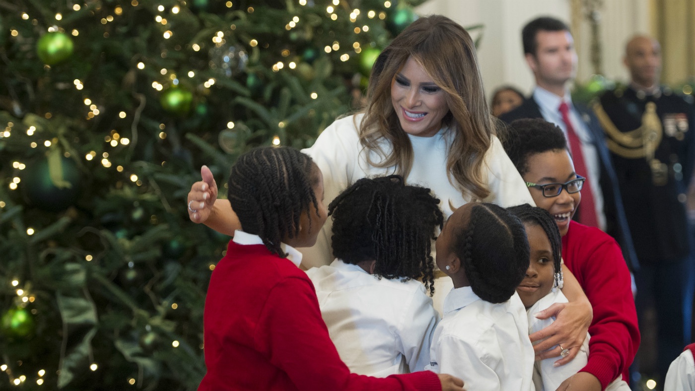 US First Lady Melania Trump hugs children in the East Room as she tours Christmas decorations at the White House in DC