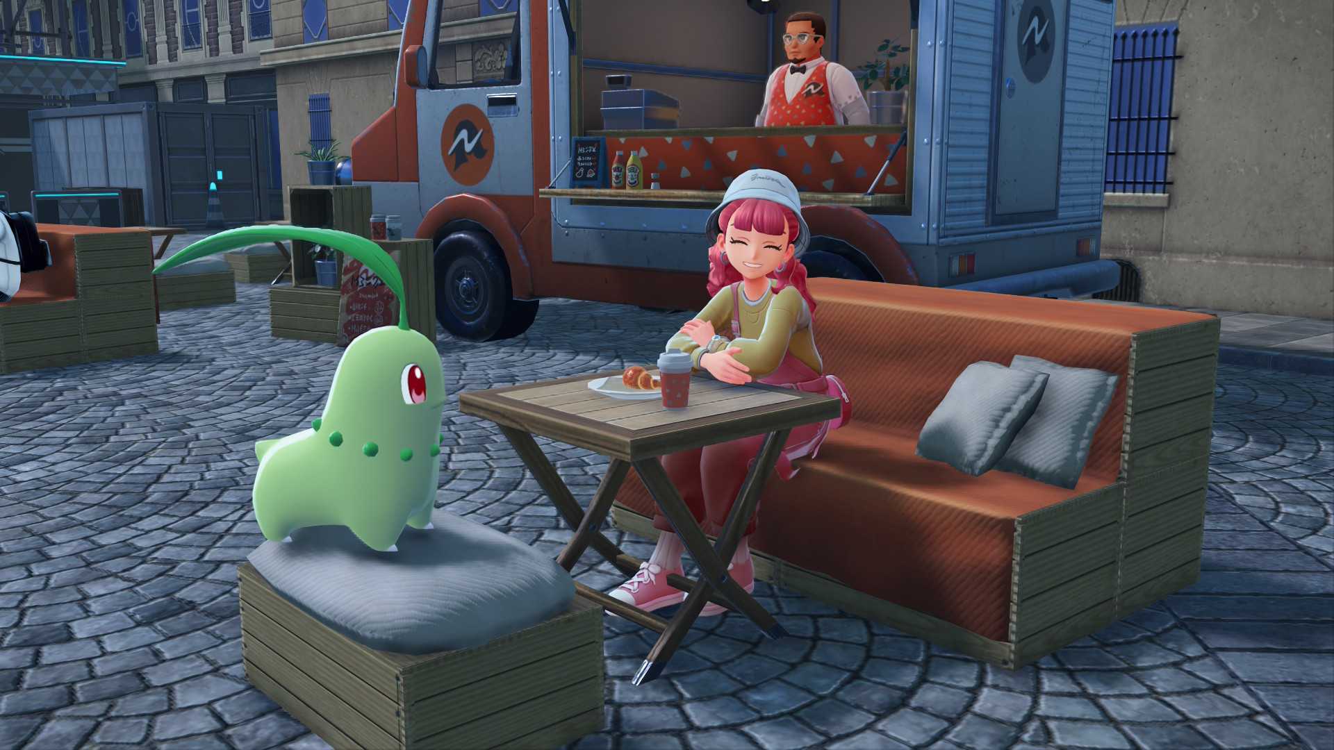 A Chikorita and a pink-haired trainer sit outside a cafe in Pokemon Legends: Z-A.