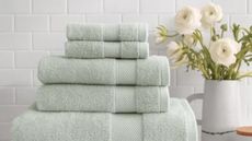 Sage green Wamsutta towels on a counter.