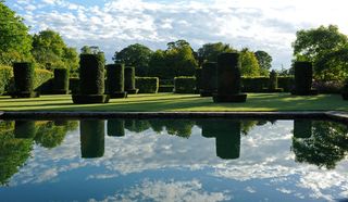 The Silent Garden pond, surrounded by 24 yew columns. ©Val Corbett/Country Life Picture Library