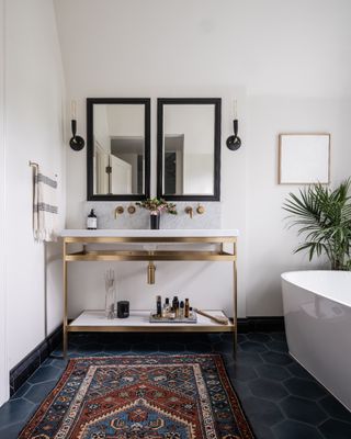 Alix Day Capitol Hill Project white bathroom with vintage rug, vanity with brass detail and a plant
