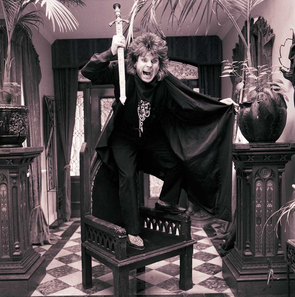 Ozzy Osbourne standing on a throne, holding a sword like a javelin