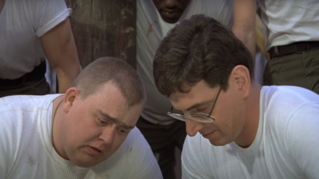 John Candy and Harold Raimis looking down at the ground together in Stripes.