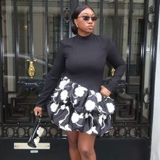 @nnennaechem posing in black rotate mini dress with black and white printed bubble hem