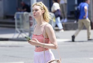 Elle Fanning wearing a white maxi skirt and striped tank top in New York