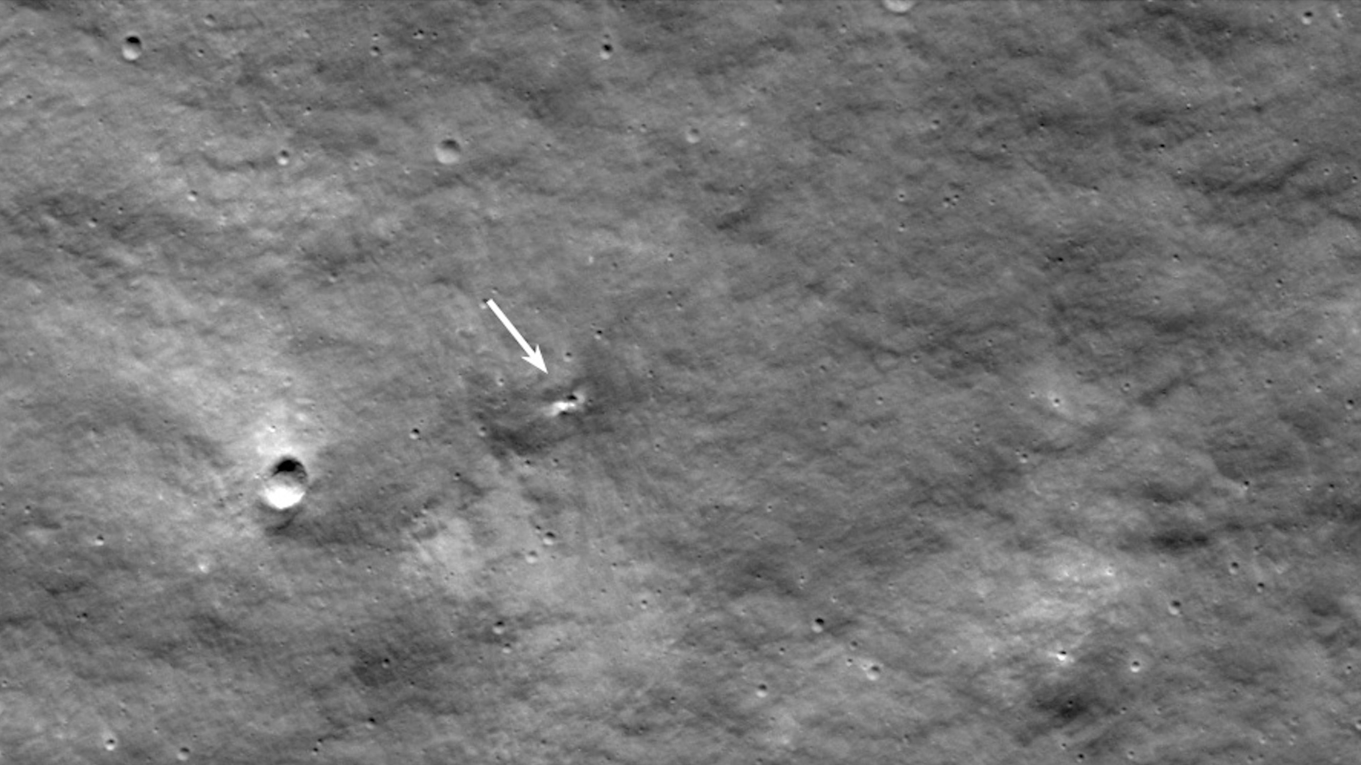 A small crater on the gray surface of the moon