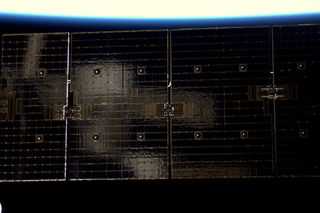 Soyuz Reflected in one of Dragon's Solar Panels