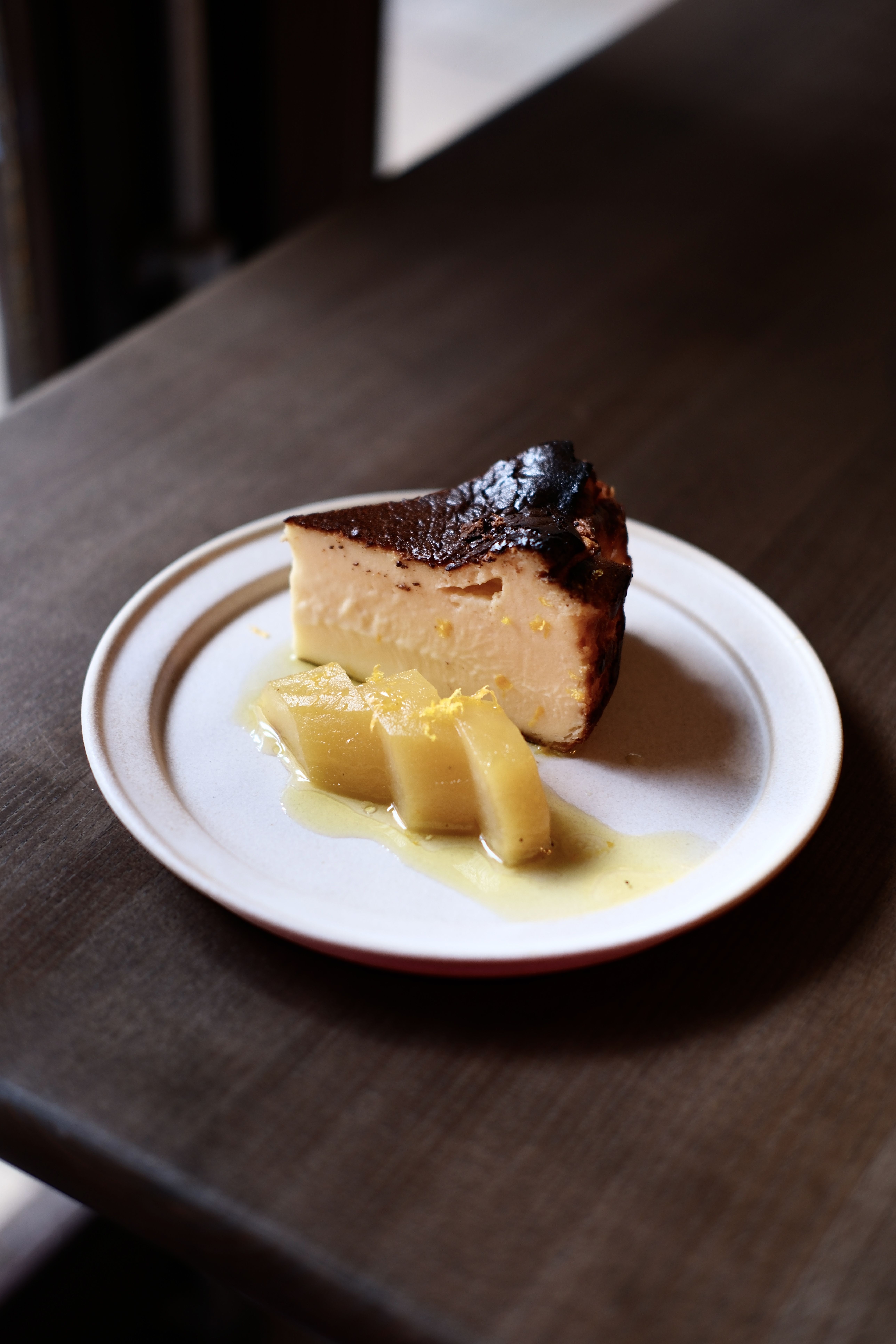 A Basque cheesecake served with pickled fruit, lemon peel, and a syrupy dressing.