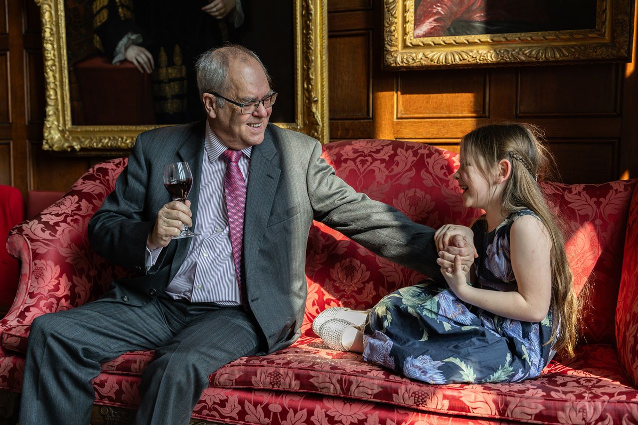 Photo titled Between Generations, taken by Fran Hales. It shows a tender moment between a grandfather and his grand-daughter at a Silk's Day lunch in London's legal district, UK.