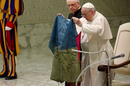Pope Francis kisses Ukrainian flag