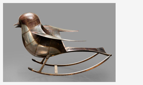 An object of a metallic bird on a rocking horse. 