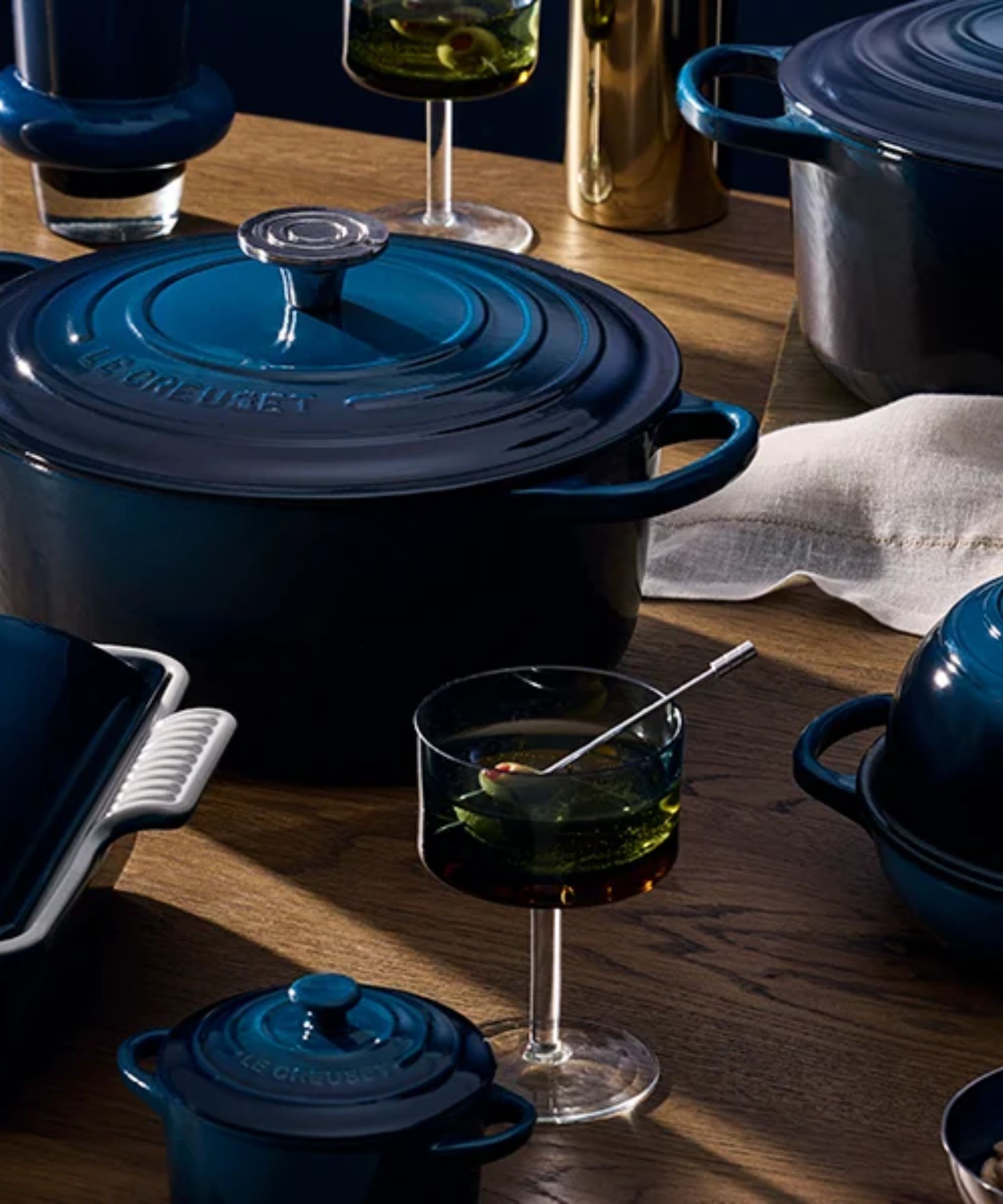 Dark blue Le Creuset cookware on a wooden table