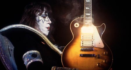 Ace Frehley holds a smoking hot Les Paul, with heat and light emitting from that neck humbucker position