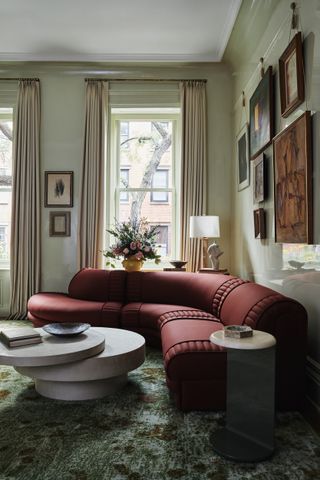 green living room in a New York townhouse with a red curved sofa