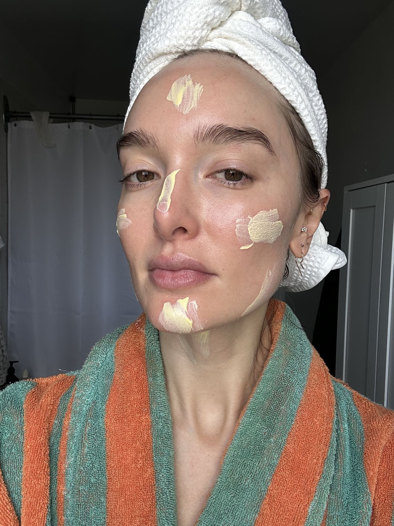 a girl in a green and orange robe and head towel before applying spf.