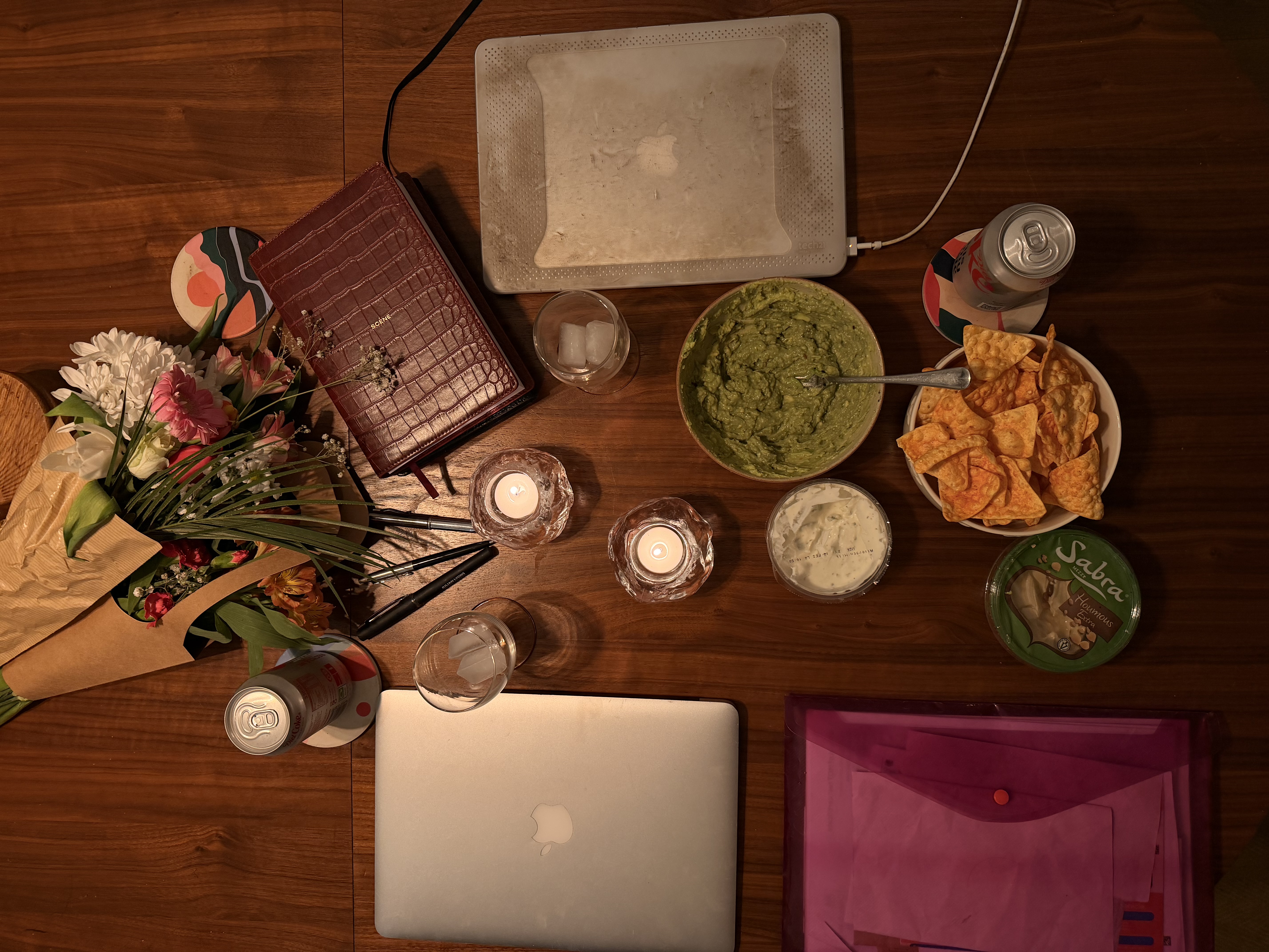 An aerial shot of a table of laptops, folders and snacks ready for a study session