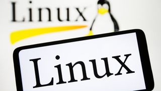Linux branding displayed on a smartphone with penguin logo pictured in background.