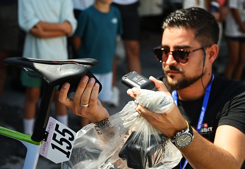 A representative from Swiss Timing installs a GPS tracker on the bike of Noelle Ingold (Nexetis) before the Tour de Romandie 2025