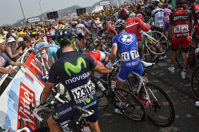 Riders try to get to the finish behind the crash-blocked road