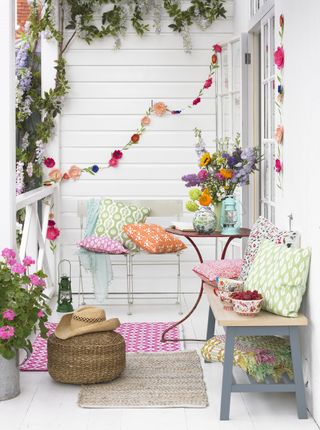 A festival style outdoor space with bright bunting and floral colour pops