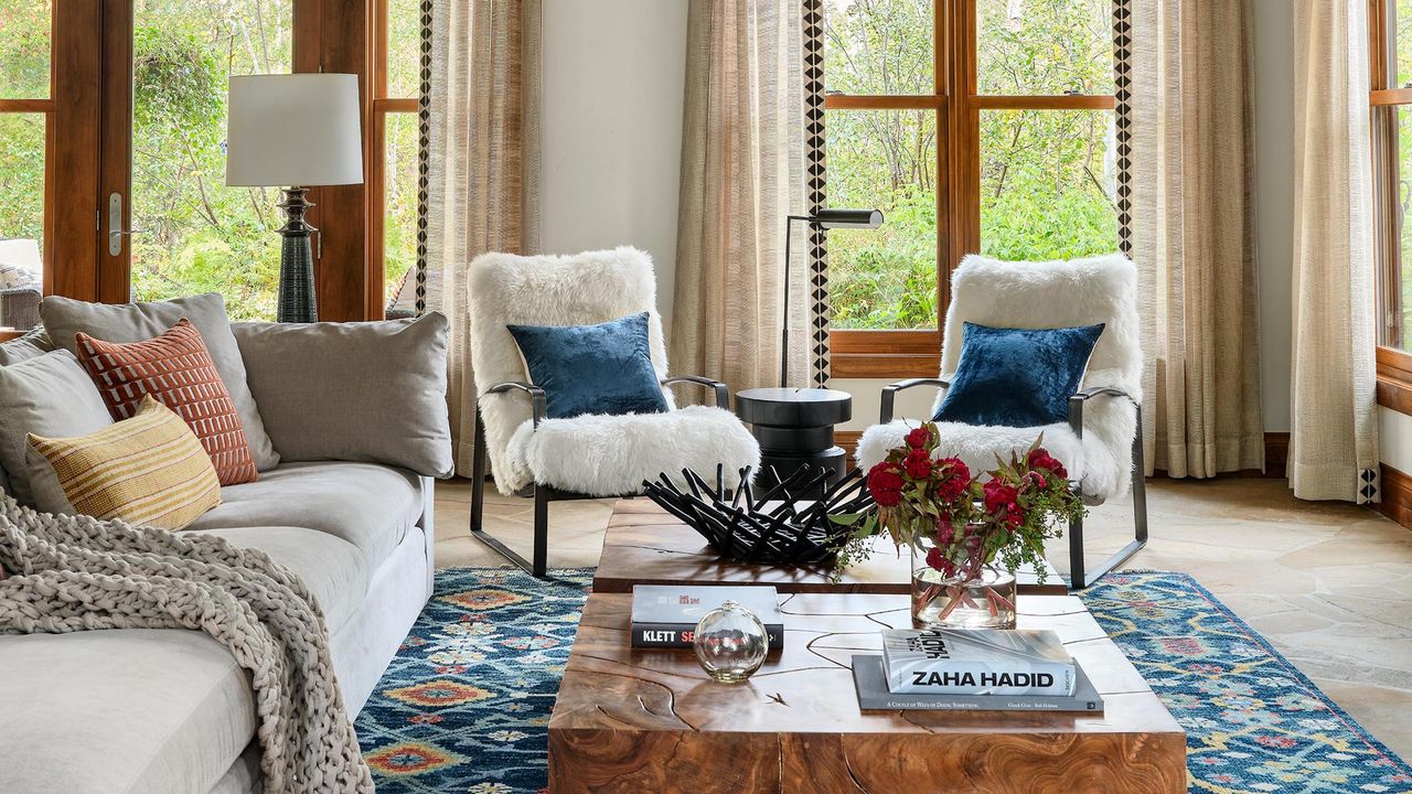 Living room with gray sofa, two sheepskin armchairs, blue patterned rug and coffee table