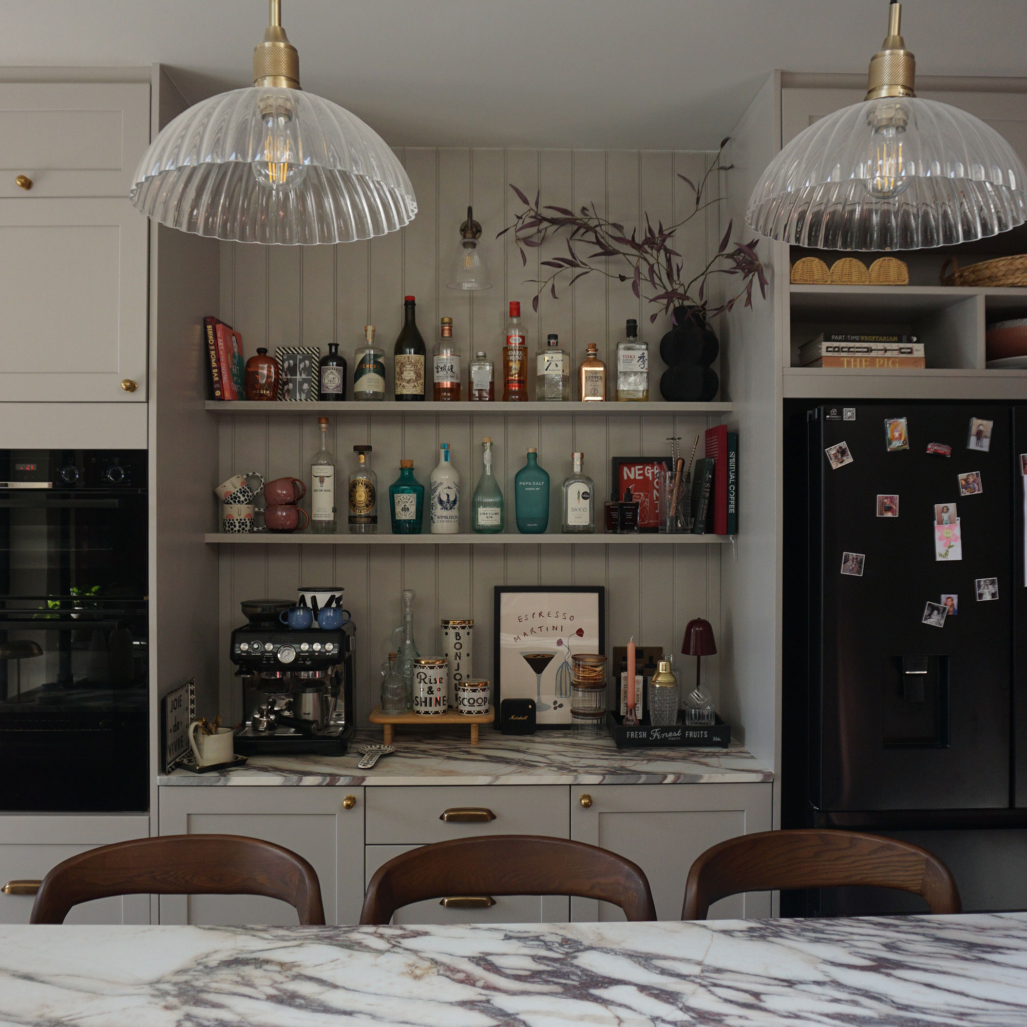 Bar area integrated into kitchen nook between built-in oven and fridge