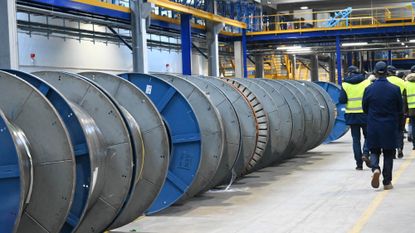 Staff at Alcatel Submarine Networks check reels of fibre-optic cable at a site in Calais, northern France