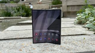 Samsung Galaxy Z Fold 6 foldable smartphone slightly hinged and standing upright on flagstones