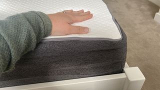Person resting their hand on the surface of the Otty Original Hybrid mattress