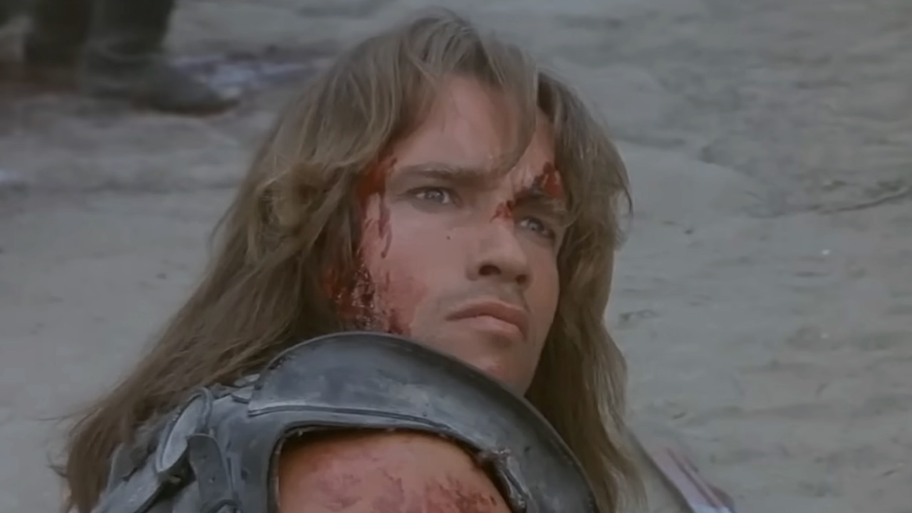 Conan laid on his side on the ground, looking up in Conan the Barbarian