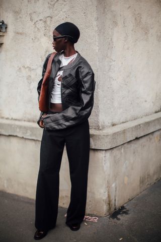 woman wearing leather racer jacket, cut-out top, black jeans, and black boots