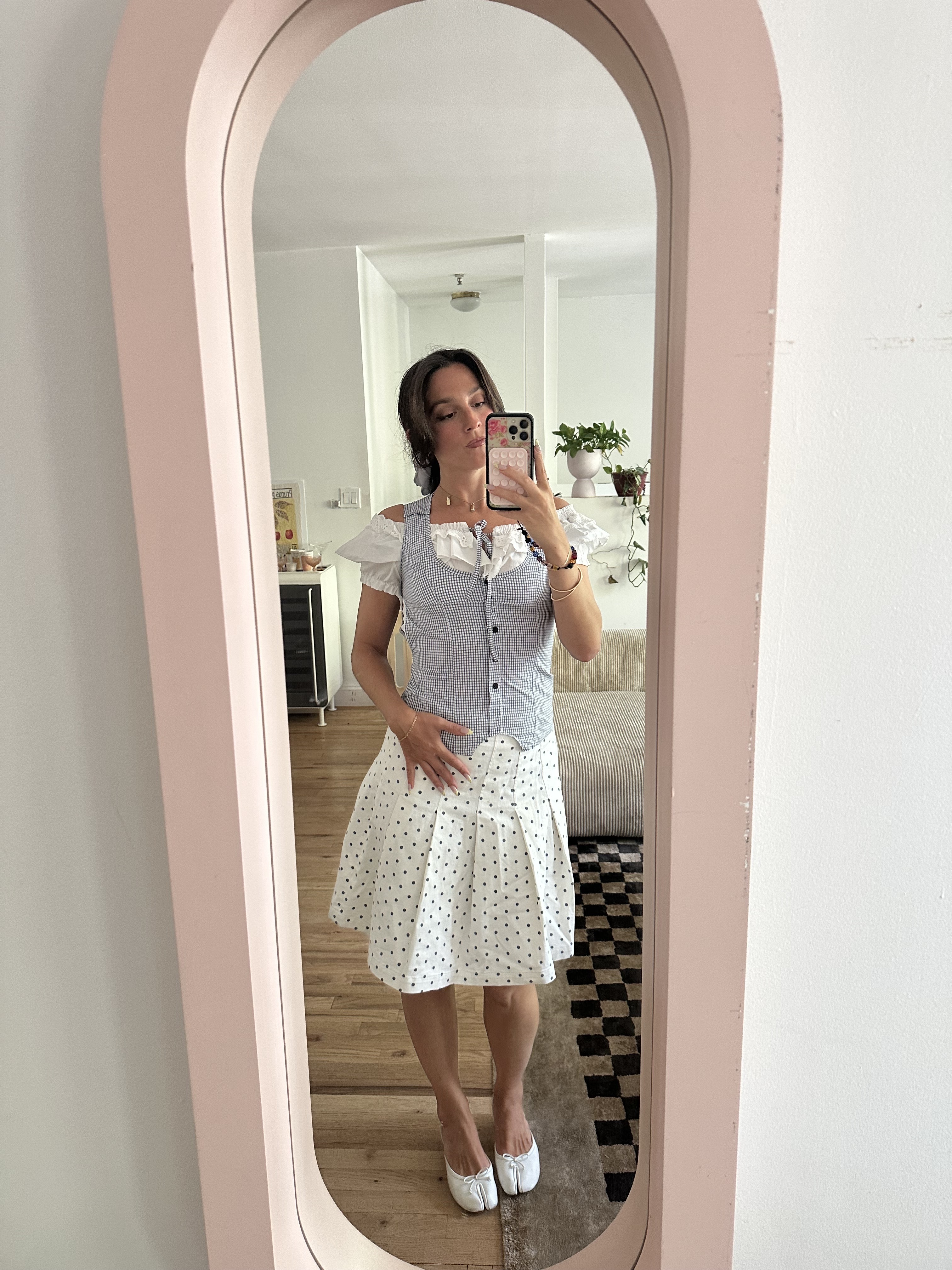 Tara Gonzalez taking selfies in a polka dot skirt.