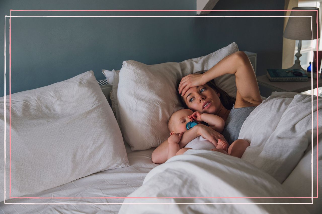 A tired mother lying in bed with a baby