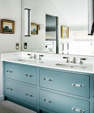 Double washbasin with blue vanity unit and large mirror
