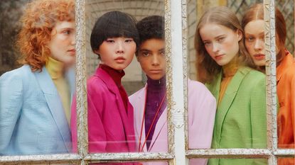 Women in a window wearing pastel jackets