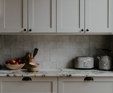 A kitchen cabinet with different styles of handle
