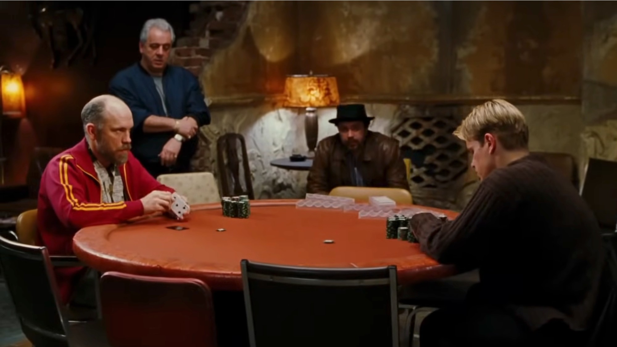 John Malkovich and Matt Damon playing poker across at an orange table in Rounders.