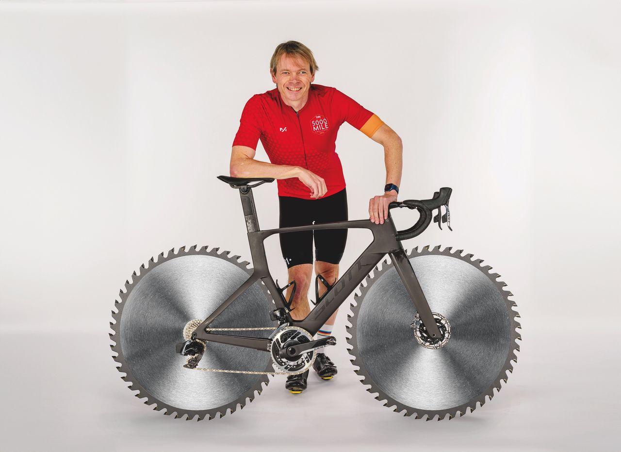 Dr Hutch poses with an imaginary bike that has circular saw blades for wheels