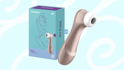 Satisfyer Pro 2 Air Pulse Stimulator, box and toy on turquoise blue background with white swirls and lines behind 