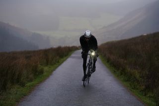 Image shows a person cycling in winter
