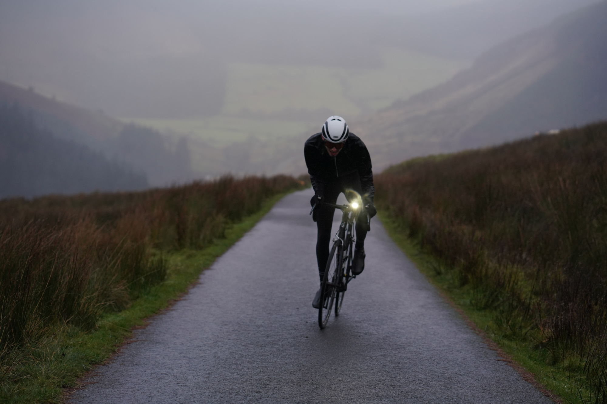 Image shows a person cycling with bike lights in winter