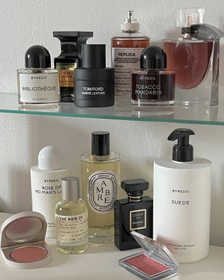 Shelf with perfume bottles and makeup products