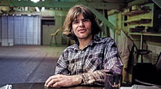 American singer and musician John Fogerty, co-founder of the swamp rock band Creedence Clearwater Revival, sits at a table and enjoys a cigarette and a Coca-Cola inside his recording studio in Berkeley, California, February 26, 1970. 